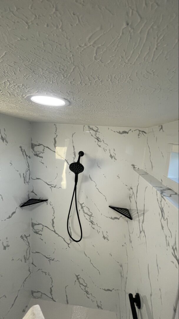 Finished walk-in shower with marble-look surround and matte black fixtures
